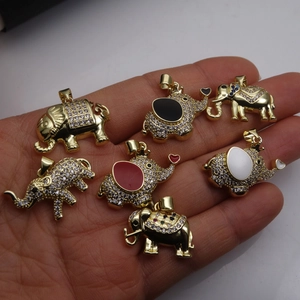 Golden elephant pendants with zircon inlay and colorful enamel shown on hand palm