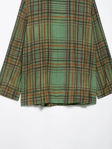 Detailaufnahme der grünen Karo-Stoffstruktur des Blazers mit klassischem Karomuster