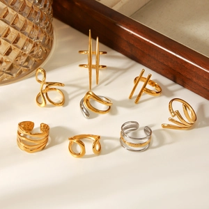 Close-up of gold and silver minimalist irregular adjustable rings on a wooden display