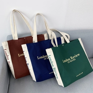 Tre borse tote in tela colorate in rosso vintage, blu navy e verde in stile college