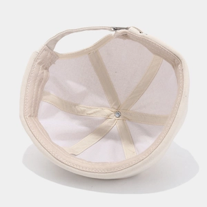 Inside view of beige cotton canvas docker cap showing six-panel stitching and metal rivet