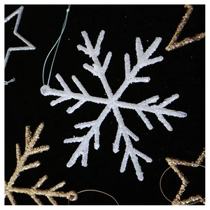 Detailed view of sparkling champagne snowflake ornaments with glittery finish on black background
