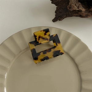 Macro view of small square acetate hair claw clip with brown leopard tortoise pattern
