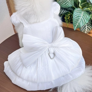 Detail of white pet wedding dress with satin bow and metal D-ring for leash attachment