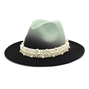 Detail of gradient wool fedora with white ribbon and elegant pearl embellishments