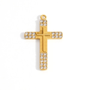 Detailed view of golden cross pendant with double rows of sparkling cubic zirconia