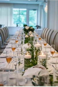Elegante drijvende witte kaars in glazen cilindervaas voor romantische bruiloftstafel