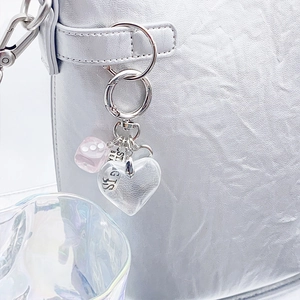 Pink dice and heart bead charm keychain attached to a silver bag for trendy styling