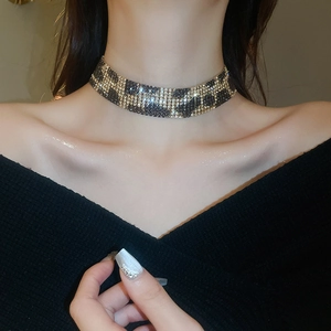 Close-up of model wearing a wide gold and black rhinestone leopard print choker necklace