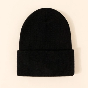 Détail du bonnet en maille noire épaisse avec revers et texture de tricotage nette