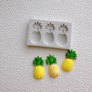 Detailed white silicone mold for creating small pineapple-shaped fondant and cake decorations