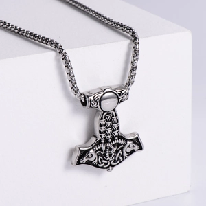 Pendentif Marteau de Thor viking en acier argenté sur support géométrique blanc épuré