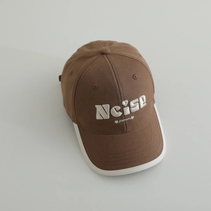 Dettaglio del cappellino in cotone marrone con ricamo Noise bianco e bordo a contrasto