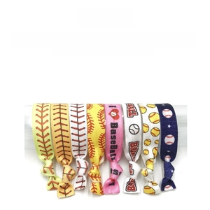 Detail showing elastic softball hair ties with yellow stitching and baseball patterns