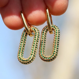 Detailed macro view of 18K gold plated huggie earrings with green zircon oval drops
