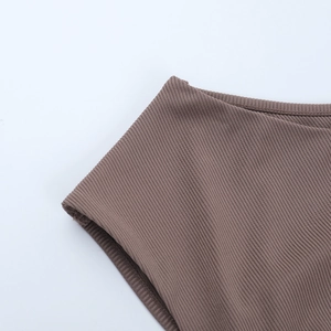 Detailed view of the brown ribbed knit fabric texture and fine stitching on the dress
