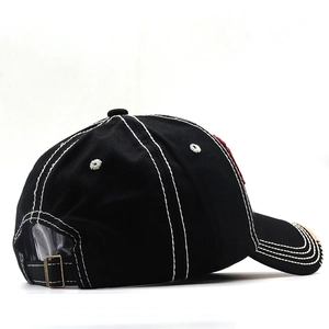 Detail of black cotton baseball cap showing white contrast stitching and metal buckle strap