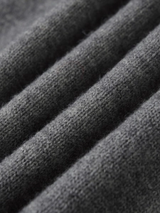 Close-up of deep grey knitwear fabric showing fine texture and soft fuzzy wool surface
