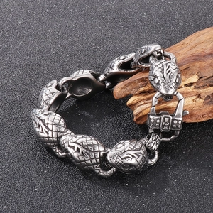 Detail shot of a 15mm stainless steel snake head bracelet on a natural wood element