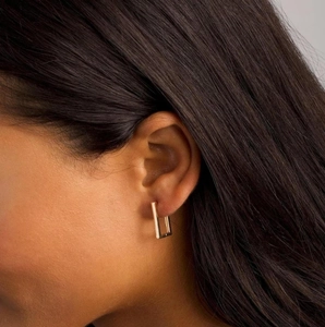 Close-up of model wearing a minimalist square gold-plated stainless steel earring