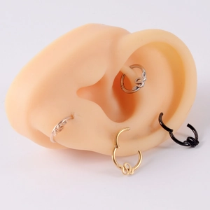Detailed view of snake-shaped ear hoops in silver, gold, rose gold and black finishes