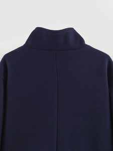 Detailed back view of navy blue wool coat featuring standing collar and precise seams