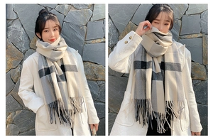 Detail shot of classic black and grey plaid scarf with long fringe and thick soft texture