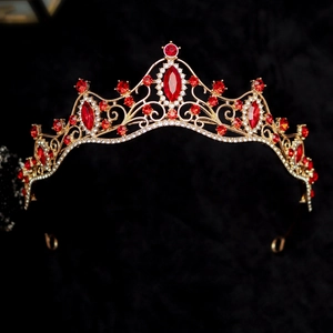 Macro detail of royal gold crown with red marquise gems and white rhinestones