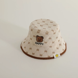 Close-up of beige corduroy kids bucket hat featuring cute bear embroidery and happy text