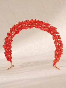 Detailed view of red crystal beads and gold wire weaving on bridal headband