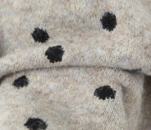Dettaglio del tessuto a maglia morbida a pois con trama in misto lana premium