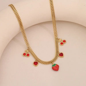 Detail view of gold chain necklace featuring red strawberry, cherry and heart pendants