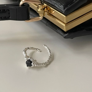 Macro shot of S925 silver ring featuring a black round stone and lava-like surface