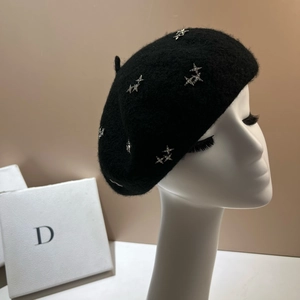 Detail of black wool beret featuring silver star studs and plush lambskin texture