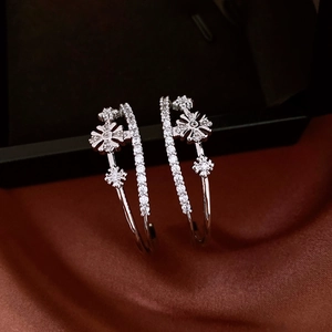 Macro shot of silver-plated flower-shaped zirconia on double-layered C-shaped earrings