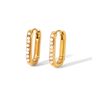 Detail view of gold-plated oval huggie earrings with a vertical row of white pearls