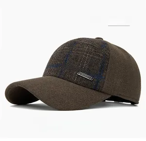 Détail de la casquette d'hiver à carreaux marron avec cache-oreilles et logo métal