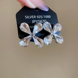 Close-up of 925 sterling silver flower earrings with clear crystals on a price tag