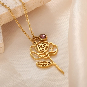 Macro shot of an 18k gold plated rose pendant necklace with a purple birthstone accent