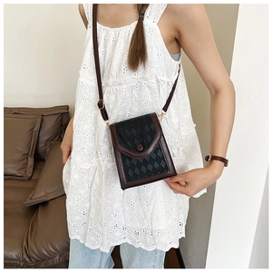 Détail du sac de téléphone avec motif à losanges noirs et finitions en cuir marron