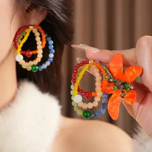 Vintage style colorful multilayer beaded earrings with a vibrant orange resin flower