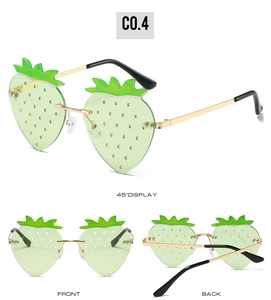 Detailed views of creative strawberry sunglasses with green lenses and gold metal frames