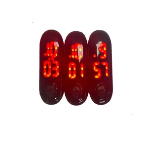 Close-up of three waterproof LED digital watch modules with red touch display in oval cases