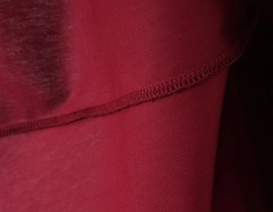 Vue macro de la texture du tissu rouge et des coutures précises d'une robe moulante