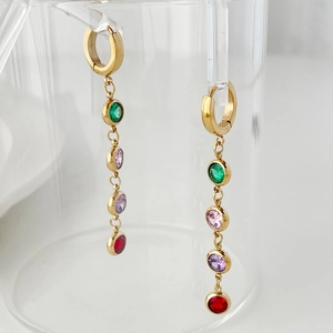 Detail of long gold drop earrings featuring vertically set green, pink, purple, and red zircons