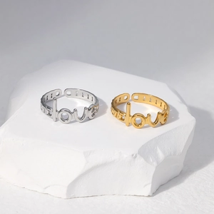 Macro detail of gold and silver steel love rings on a white stone pedestal