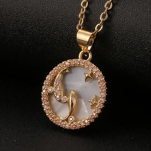 Macro detail of gold zodiac pendant with white mother of pearl and pink zircon stones