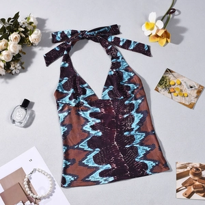 Detailed view of snake print halter top with deep V-neck and mesh patchwork on flat lay