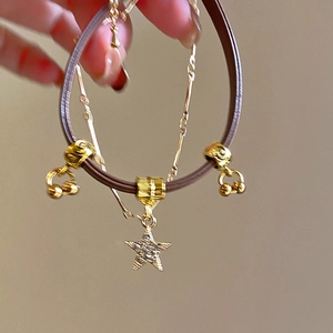 Macro view of French retro sun pendant necklace with brown leather and gold chain