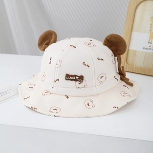 Détail d'un chapeau cloche crème pour bébé avec oreilles d'ours et patch en cuir décoratif